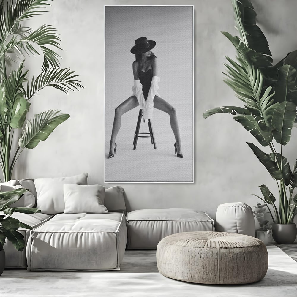 Tablou canvas cu tablou canvas cu femeie pe scaun, in rama de aluminiu argintiu, pe perete intr-un living